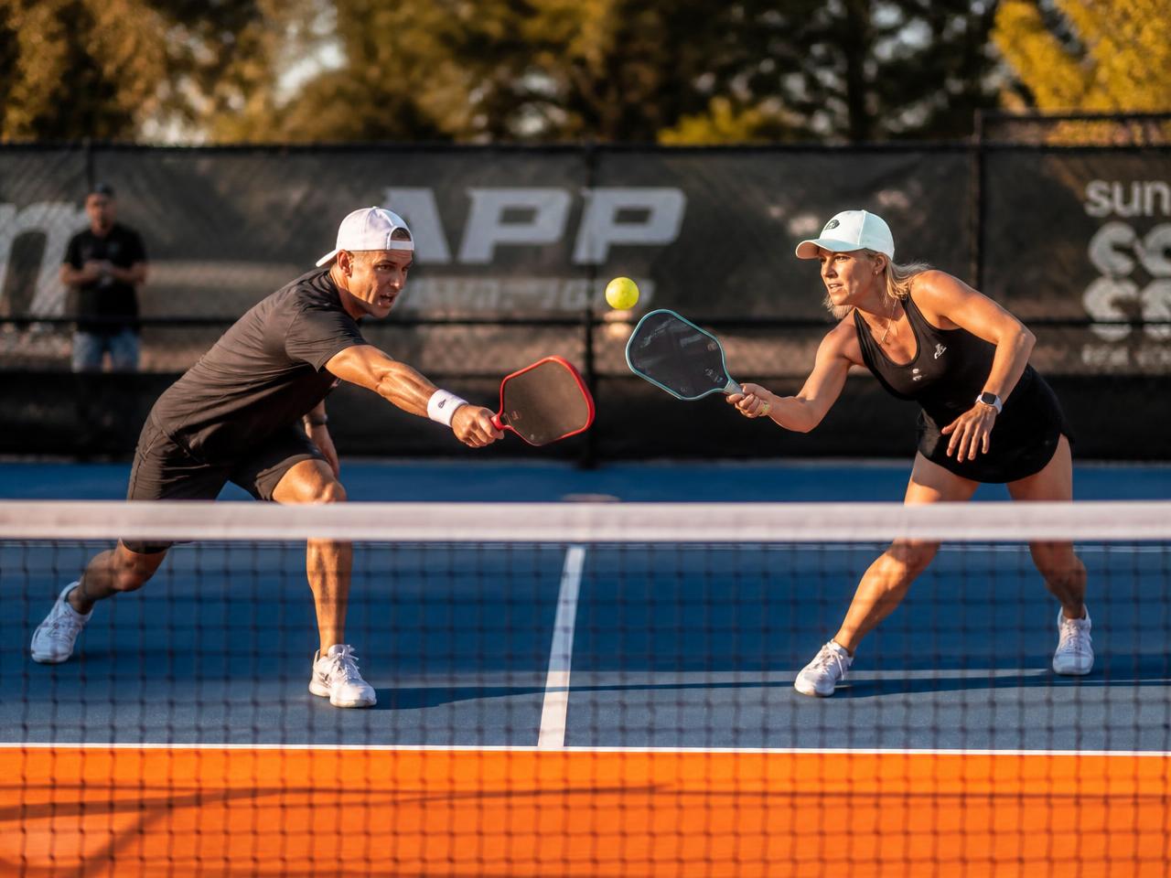 Jugadores durante un partido de pickleball en la red