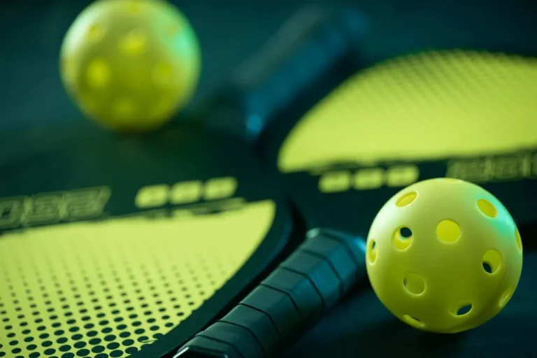 Palas y pelotas de pickleball colocadas sobre una pista